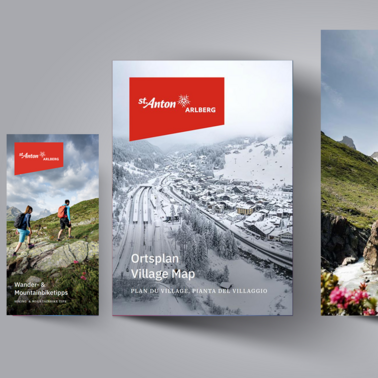 Three St. Anton brochures with summer and winter themes side by side.