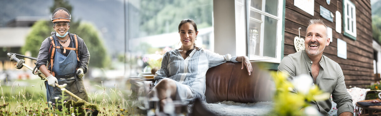 Ein Mann mit Schutzkleidung und Helm arbeitet mit einer Motorsense auf einer blühenden Wiese. Er lächelt in die Kamera. Eine Frau sitzt entspannt auf einem braunen Ledersofa in einem hellen Raum mit Ausblick auf grüne Berge. Ein lächelnder Mann steht in einem üppigen Gemüsegarten mit Bergkulisse. Er trägt ein olivgrünes Hemd und deutet mit der Hand auf das Gemüse.