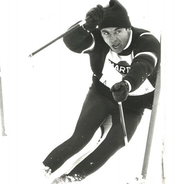 Karl Schranz fährt mit hoher Geschwindigkeit durch einen Slalomkurs. Die Aufnahme ist in Schwarz-Weiß gehalten.