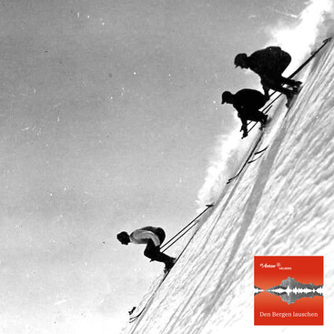 Drei Skifahrer in klassischer Rennhaltung fahren eine steile Schneepiste hinunter. Die Aufnahme ist stark geneigt und erzeugt eine dramatische Wirkung. Im Vordergrund ist der Schnee aufgewirbelt.