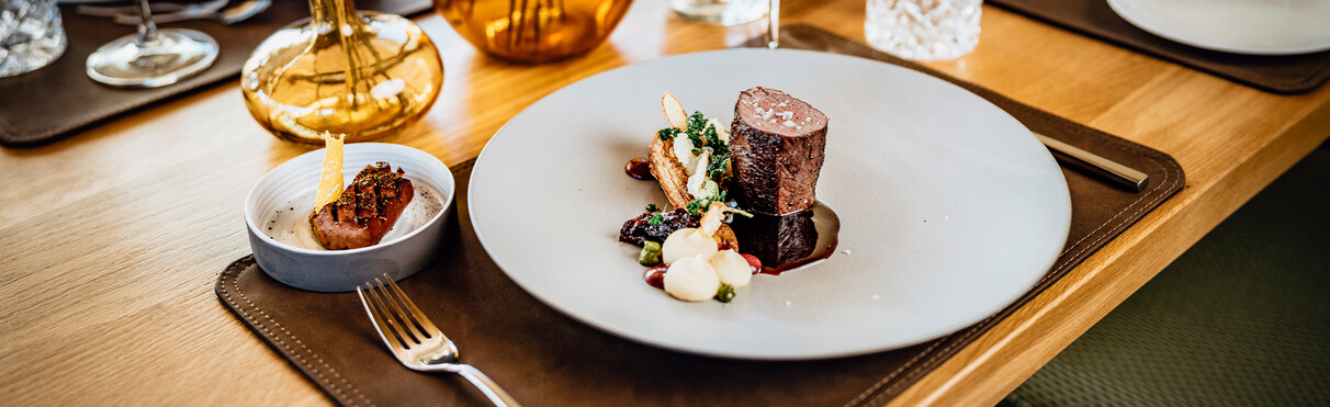 Nahaufnahme eines Rindermedaillons mit schön servierten Beilagen.