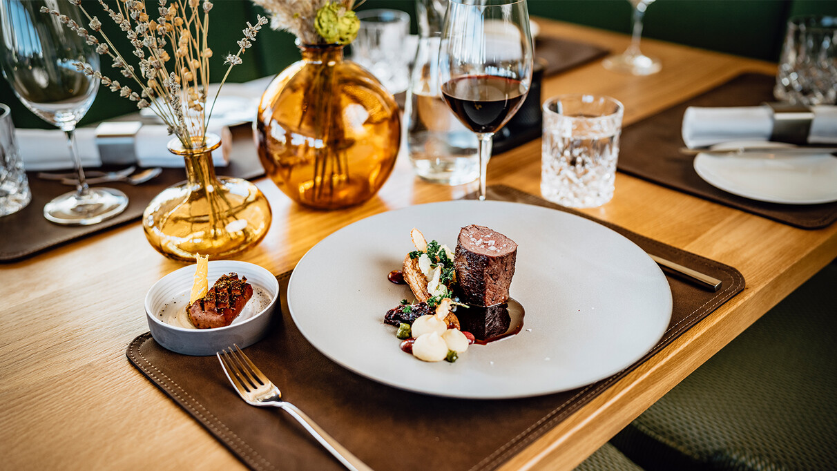 Close-up of a beef medallion with beautifully served side dishes.