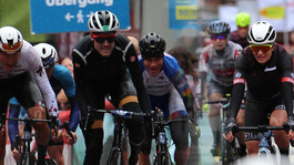 Radrennfahrer sprinten bei nasser Fahrbahn durch das Ziel beim Arlberg Giro.