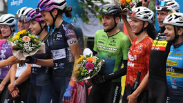 Siegerehrung beim Arlberg Giro mit Blumensträußen und strahlenden Radsportlern.