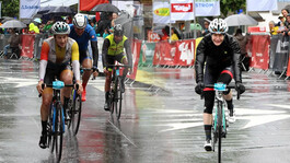 Radsportler beim Arlberg Giro fahren bei Regen durch die Zielgerade.