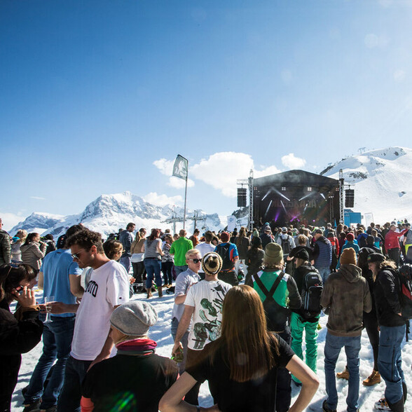 Menschenmenge vor der Bühne beim Tanzcafé Arlberg Festival im Schnee mit klarer Sicht auf Bühne und Musiker.
