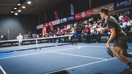 Sportler im Einsatz bei einem Pickleball-Match vor Publikum in der Halle.
