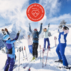 Eine Gruppe glücklicher Alpinisten in St. Anton am Arlberg mit dem Friends of St. Anton Community Logo
