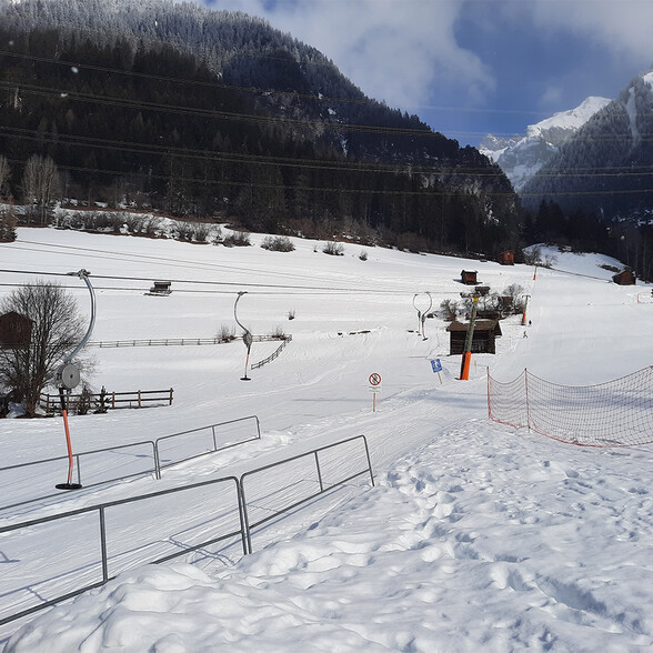 Der Flirscher Skilift mit frisch präparierter Skipiste mit Spurgerillen führt an alten Holzhütten vorbei zu einem nostalgischen Skilift im Waldgebiet von St. Anton.