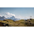Berggipfel mit Gipfelkreuz und Blick auf markante alpine Berglandschaft / Mountain peak with summit cross and view of distinctive alpine landscape