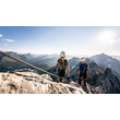 Zwei Klettersteiggeher mit Helm und Ausrüstung auf luftiger Felspassage mit Panoramablick / Two climbers with helmet and gear on exposed rocky section with panoramic view