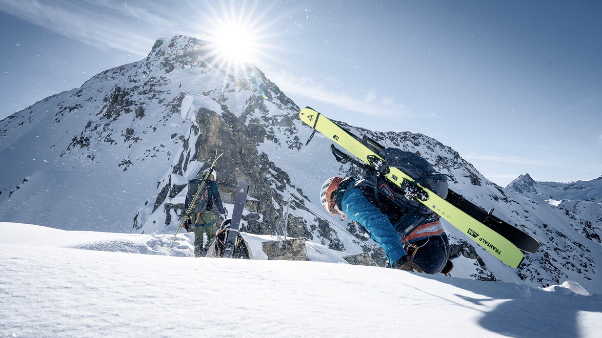 Skibergsteiger erklimmt Hang mit Gipfel im Hintergrund / Ski mountaineer climbs slope with peak in background