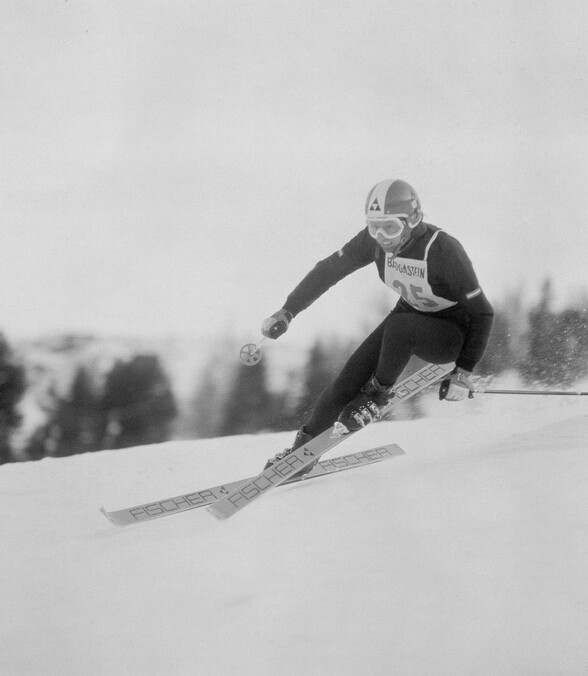 Historische Schwarzweißaufnahme von Gertrud Gabl bei einem Skirennen – dynamisch und fokussiert in der Abfahrt.