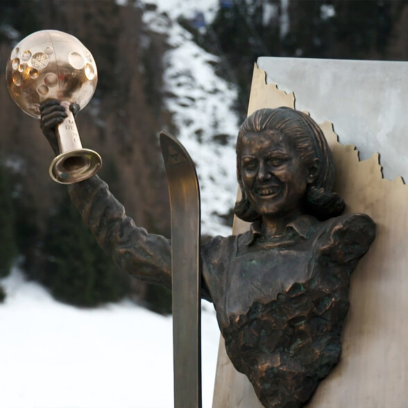 Die Bronzestatue der Skilegende Gertrud Gabl hält einen Pokal empor – ein Denkmal für ihre Erfolge im alpinen Skisport.
