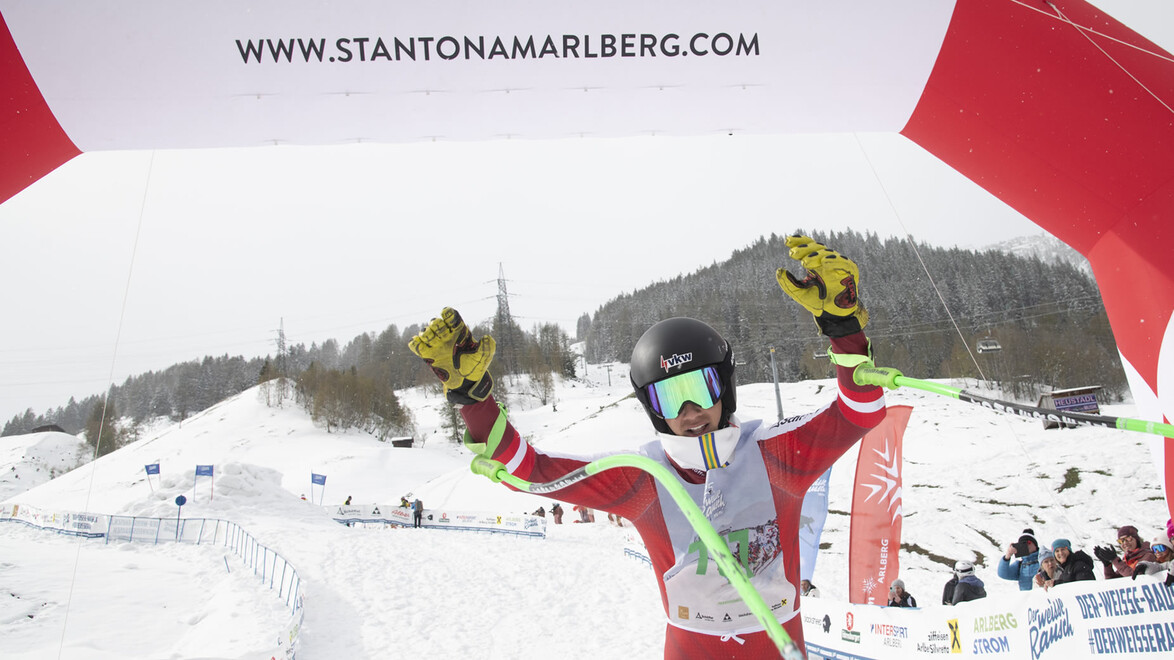 Skirennläufer jubelt mit erhobenen Armen im Zielbereich / Ski racer celebrates with raised arms at the finish line