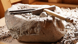 Altes Werkzeug auf einem Steinblock, ausgestellt in einem Museum zur lokalen Bergbaugeschichte.