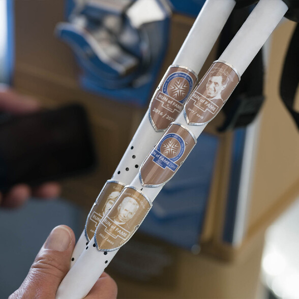 Nahaufnahme von Skistöcken mit glänzenden Run of Fame Plaketten aus St. Anton am Arlberg.