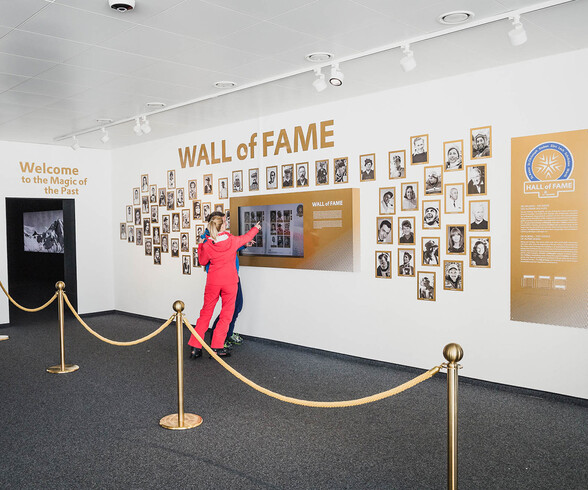 Besucher betrachten die Wall of Fame mit Ski-Legenden in der Hall of Fame St. Anton.