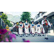 Frauen und Männer in traditioneller Tracht marschieren bei einem Festumzug durch die Straße / Women and men in traditional costumes parade through the street during a festival