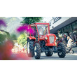 Roter Oldtimer-Traktor fährt durch das Dorf beim Festumzug, umgeben von Blumen / Red vintage tractor drives through the village during the parade, surrounded by flowers