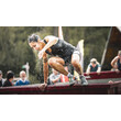 Eine Frau überquert ein nasses Hindernis bei einem Hindernislauf im Freien. / A woman crosses a wet obstacle during an outdoor obstacle race