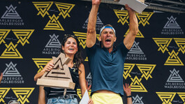 Lisa Egger und Florian Holzinger jubeln auf der Bühne als Gesamtsieger des Arlberger Wadlbeisser. 