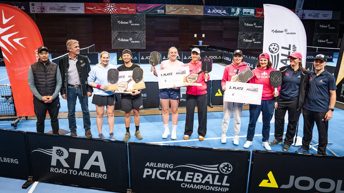 Gewinnerinnen eines Damen-Doppels stehen auf dem Podest, flankiert von Sponsoren und Offiziellen / Women's doubles winners stand on the podium, flanked by sponsors and officials