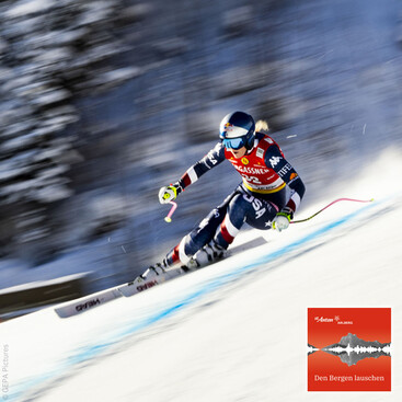 fährt dynamisch durch eine Torabfahrt bei einem Weltcuprennen, mit verschwommenem Hintergrund durch die Geschwindigkeit.