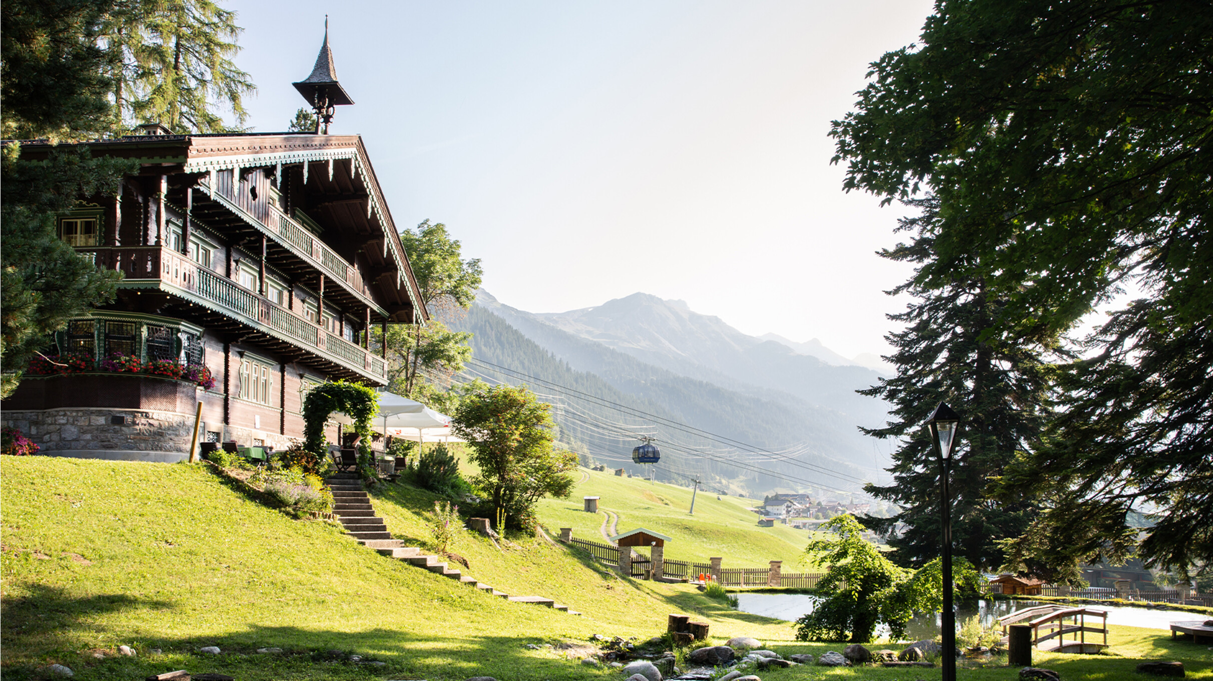Mobiliteitskaart St. Anton - Museum Die historische Villa Trier in grüner Umgebung mit Blick auf das Tal bei St. Anton am Arlberg.