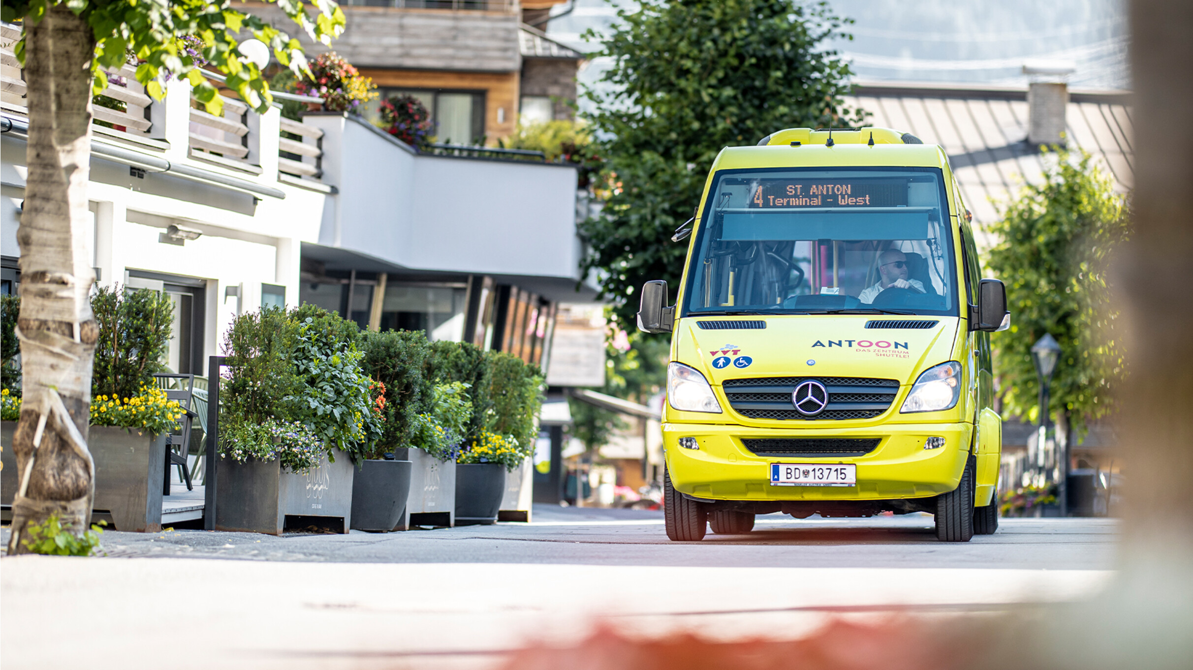 Im Sommer fährt der gelbe Dorfbus durch das Zentrum von St. Anton am Arlberg. Mobilitätskarte St. Anton – Busnutzung