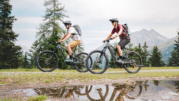Two cyclists on an e-bike tour through the mountain scenery.