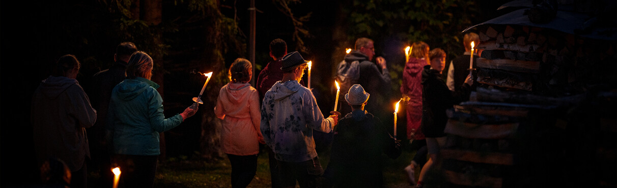 Group on a torchlit night hike through the forests of St. Anton am Arlberg