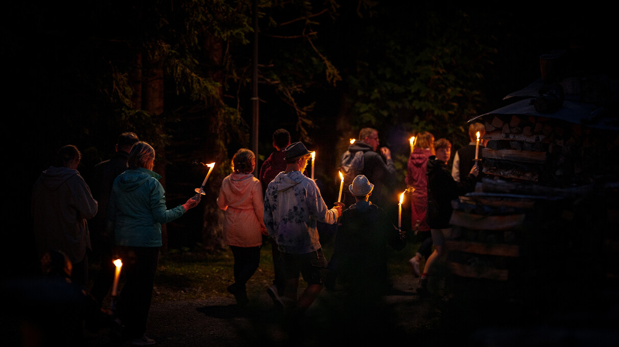Gruppe bei nächtlicher Fackelwanderung durch den Wald.