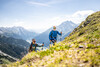 Bergaufwandern / Uphill Hiking Zwei Wanderer mit Stöcken steigen einen steilen Hang mit Blick ins Tal hinauf / Two hikers with poles ascend a steep slope with a wide view into the valley
