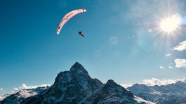 Simon Raffeiner im Gleitflug über den verschneiten Patteriol im Winter