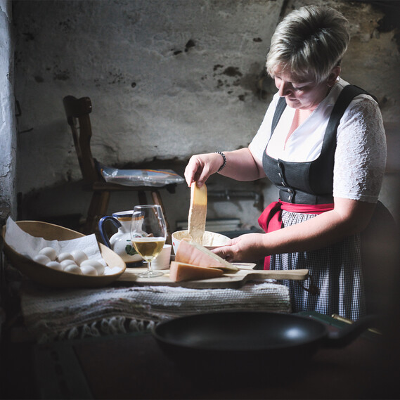 Zubereitung der Kaskiachln in einer Stahlpfanne auf einem traditionellen Kachlofen