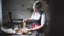 Zubereitung der Kaskiachln in einer Stahlpfanne auf einem traditionellen Kachlofen