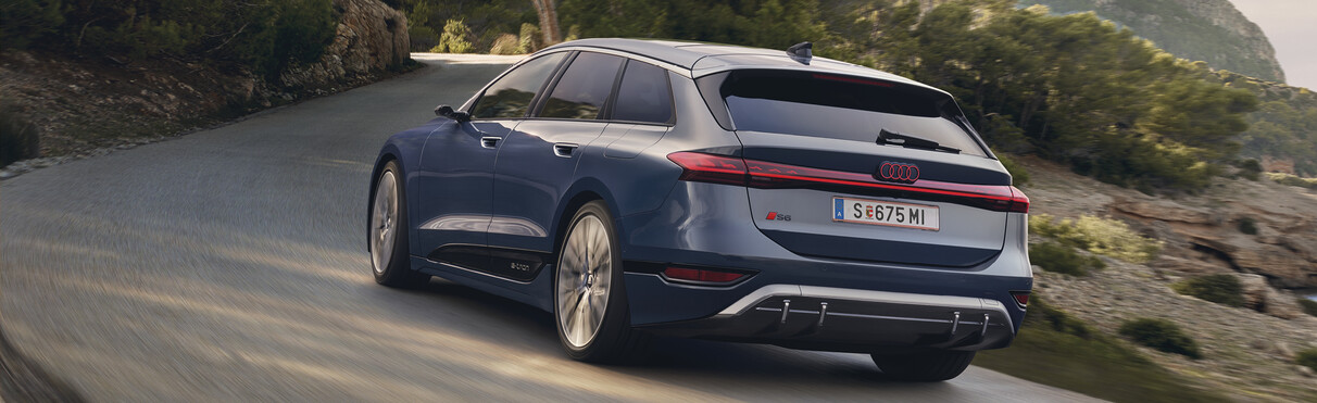 Audi S6 Avant driving on a curvy mountain road, in the background trees and a mountain can be seen