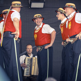 Men in traditional costume dancing at village festival.