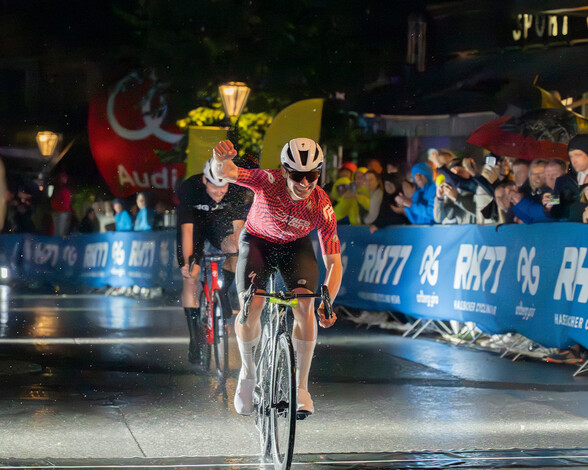 Rennradfahrer jubelt mit einer erhobenen Faust und ist sichtlich erfreut.