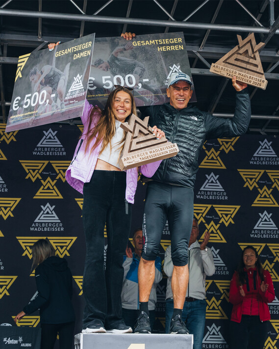 Siegerin Michalina Matusiewicz und Sieger Florian Holzinger des Arlberger Wadlbeisser stehen jubelnd auf dem Podium. 