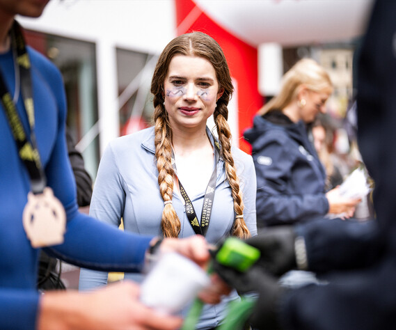 Anna Strigl steht am Start und blickt auf das Stirnband mit der Startnummer darauf.