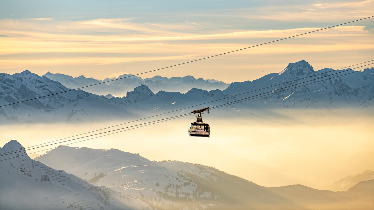 The Valluga I cable car ascends against a wintery Alpine panorama in a sea of fog.