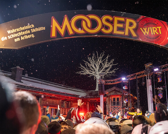 Cheering party crowd under the Mooserwirt entrance portal at the annual Schlagerliebe by night
