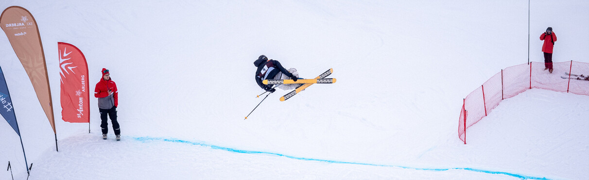 Skifahrer macht eine Drehung über einen großen Kicker.