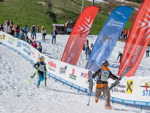 Zwei Kinder rennen freudig über die Ziellinie des Weissen Rausch Mini
