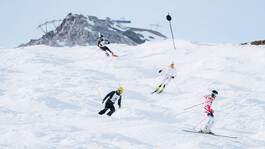 Athleten rasen die buckelige Kandahar Skipiste hinunter.