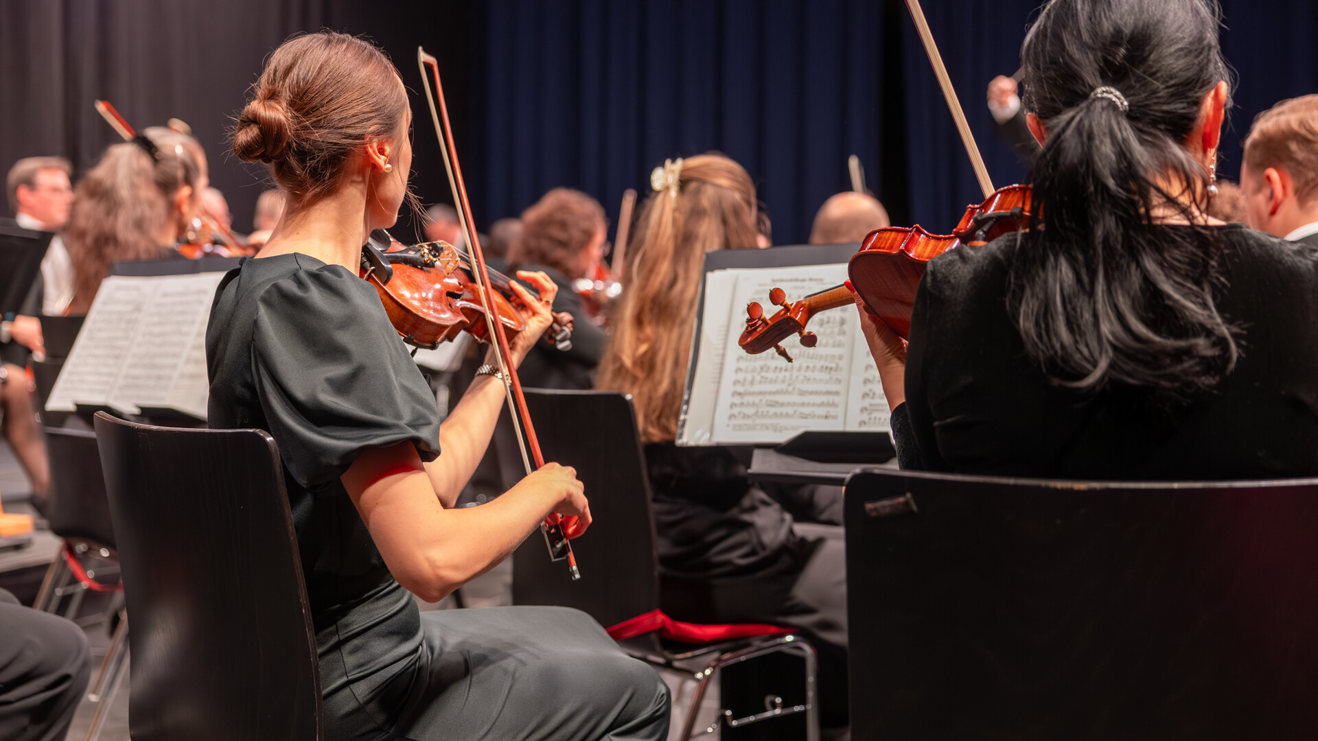 Geigerinnen im Orchester / Violinists in the orchestra Geigerinnen im Orchester während des Konzerts / Violinists performing during the concert