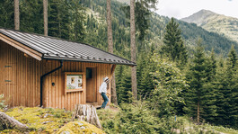 A buzzing diversity project for the Arlberg region A person wearing a beekeeper suit exits the bee house in the Verwall valley.