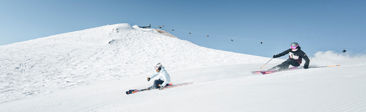 Due sciatrici scendono con lo stile carving su una pista a St. Anton